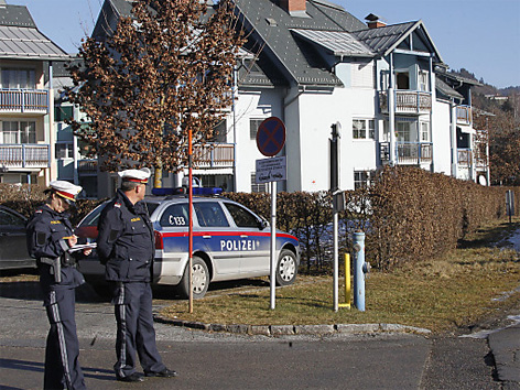 Polizisten vor dem Haus in Maria Rain, in dem der Mord passiert ist